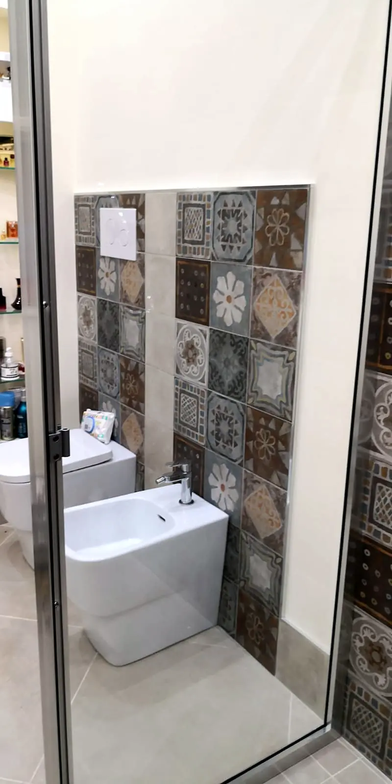 Bagno con rivestimento in piastrelle decorate effetto cementina