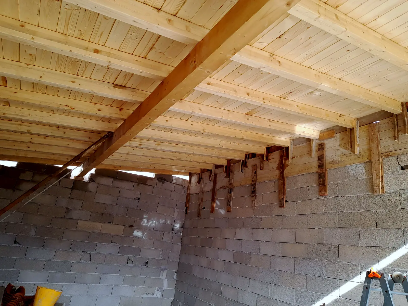 Copertura in legno con travi e perlinato su muri in blocchi