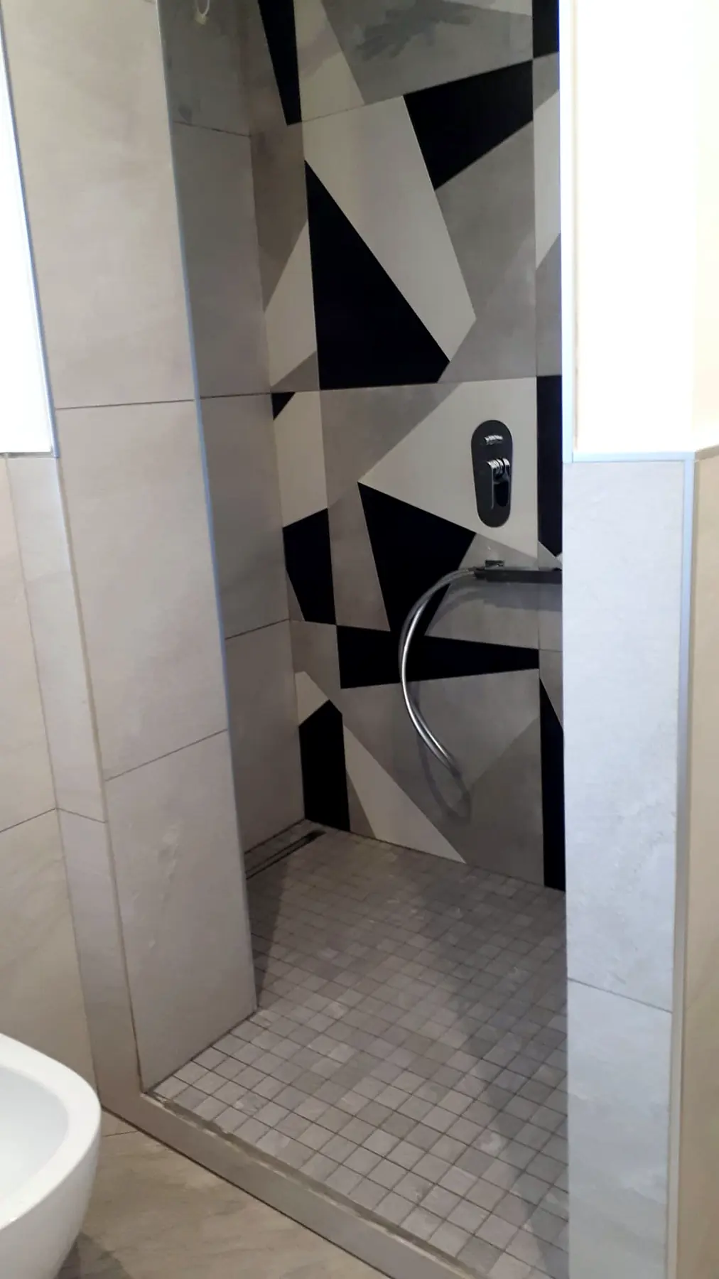 Doccia con rivestimento geometrico bianco, grigio e nero