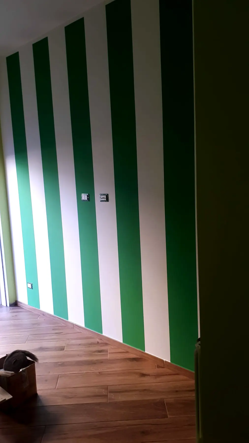 Parete decorata a righe verticali verdi e bianche