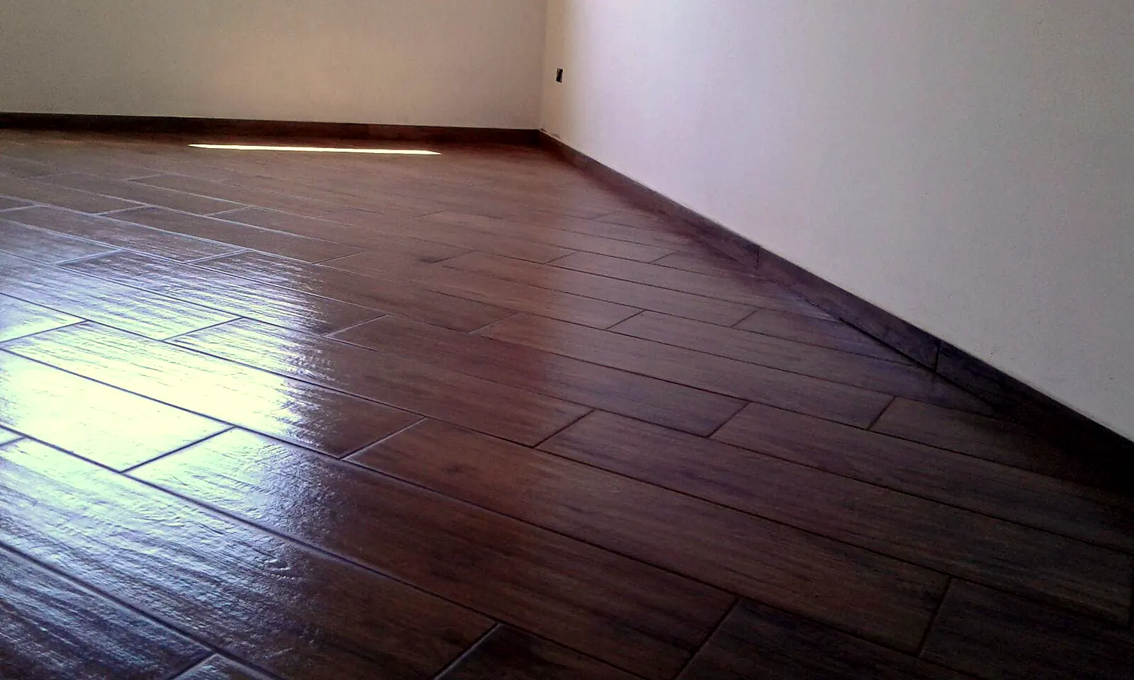 Pavimento in gres effetto legno appena posato, con battiscopa