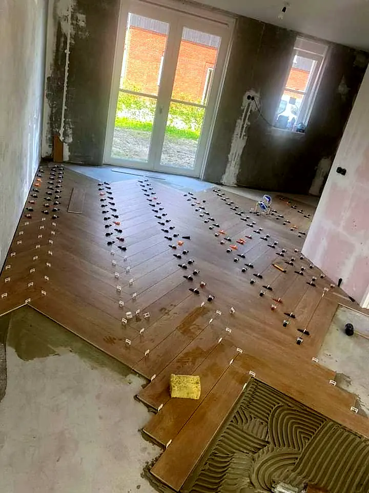 Posa di un pavimento effetto legno a spina di pesce sul massetto